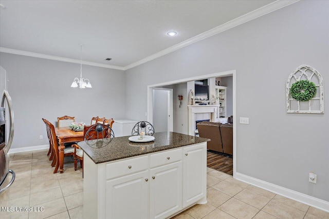 115 Victoria Pl, Brandon, MS 39042 - kitchen featuring crown molding, light tile patterned flooring, a fireplace, a chandelier, and white cabinets