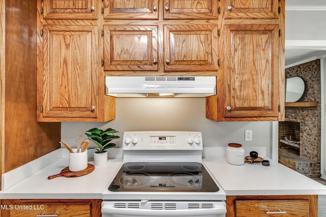 114 Fern Valley Rd, Brandon, MS 39042 - kitchen with under cabinet range hood, white range with electric cooktop, light countertops, a brick fireplace, and brown cabinets
