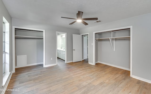 114 Fern Valley Rd, Brandon, MS 39042 - unfurnished bedroom with two closets, light wood-type flooring, baseboards, and a ceiling fan
