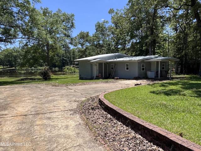 206 C St, Brandon, MS 39042 - back of house featuring driveway, a yard, and view of wooded area