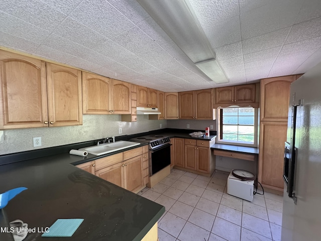 206 C St, Brandon, MS 39042 - kitchen with a sink, range with electric cooktop, under cabinet range hood, dark countertops, and light tile patterned floors