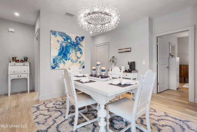 dining room with visible vents, an inviting chandelier, baseboards, and light wood-style floors