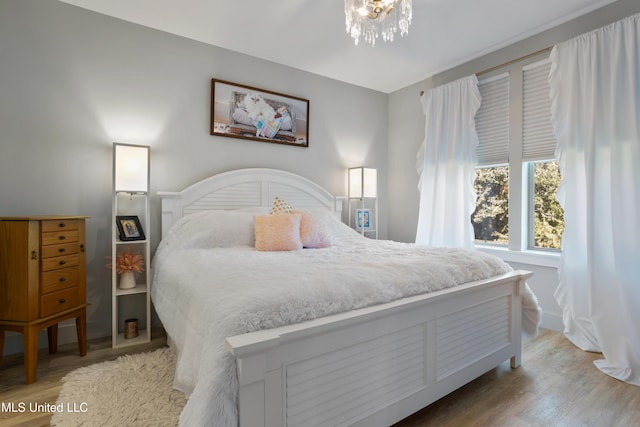 bedroom with a chandelier and wood finished floors