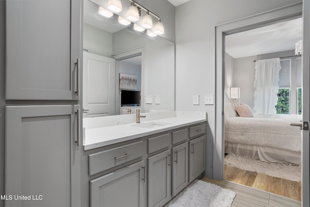 bathroom featuring vanity, ensuite bathroom, and wood finished floors