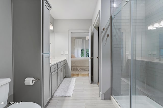 bathroom featuring connected bathroom, vanity, toilet, and a shower stall