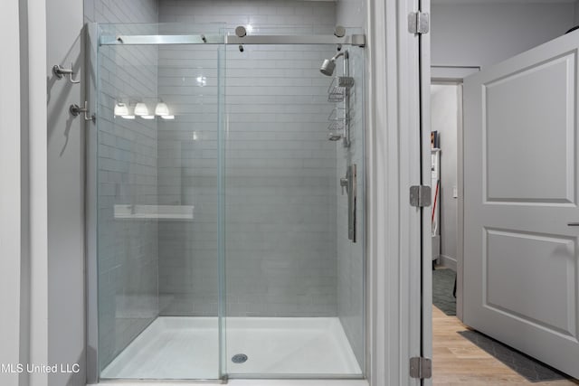 bathroom featuring a stall shower and wood finished floors