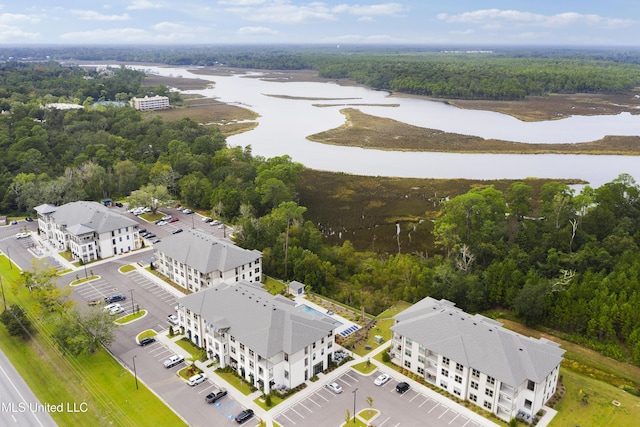 birds eye view of property with a water view and a wooded view