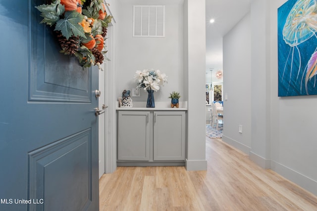 entryway featuring light wood-style flooring, baseboards, and visible vents