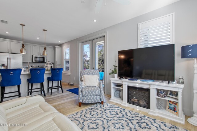 living room featuring visible vents, recessed lighting, a ceiling fan, and light wood-type flooring