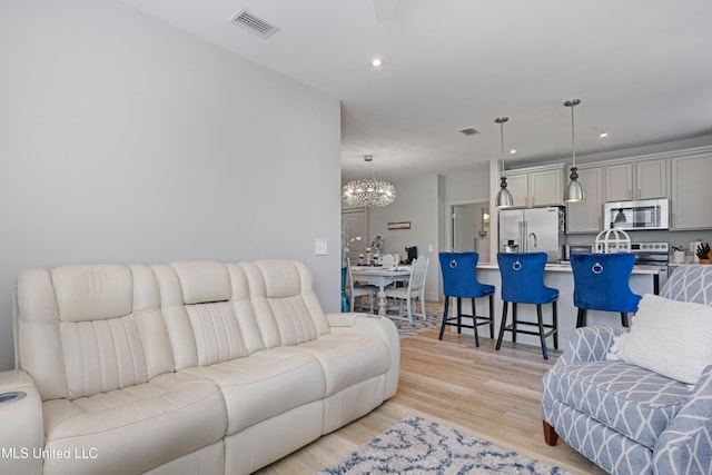 living room featuring an inviting chandelier, recessed lighting, light wood-style floors, and visible vents