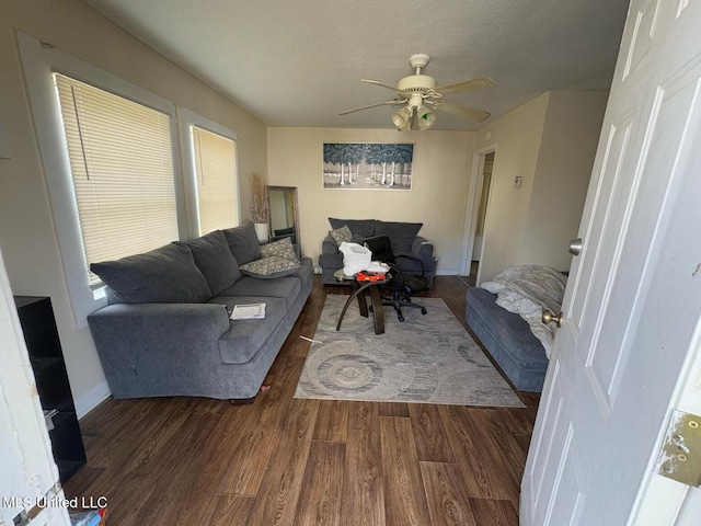 living room featuring ceiling fan, dark hardwood / wood-style floors, and a textured ceiling