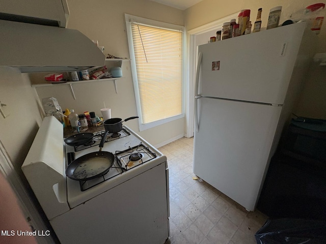 kitchen with white appliances and range hood