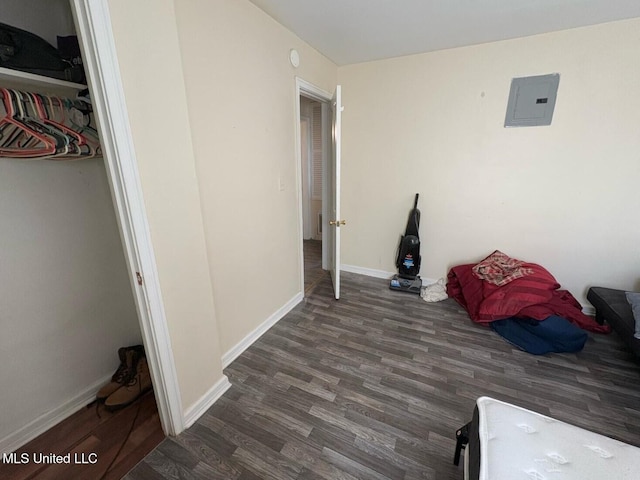 bedroom featuring electric panel and dark hardwood / wood-style flooring