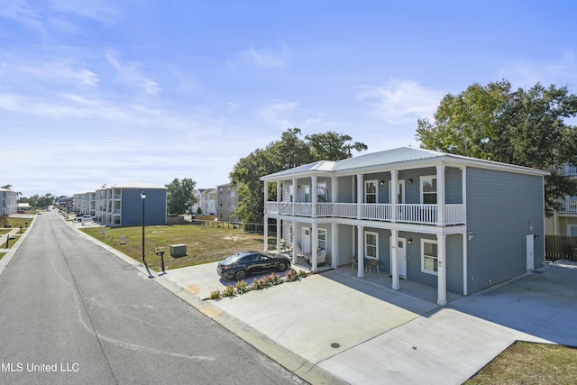 56 Oak Alley Ln, Long Beach, MS 39560 - view of front facade with a balcony, covered porch, and driveway