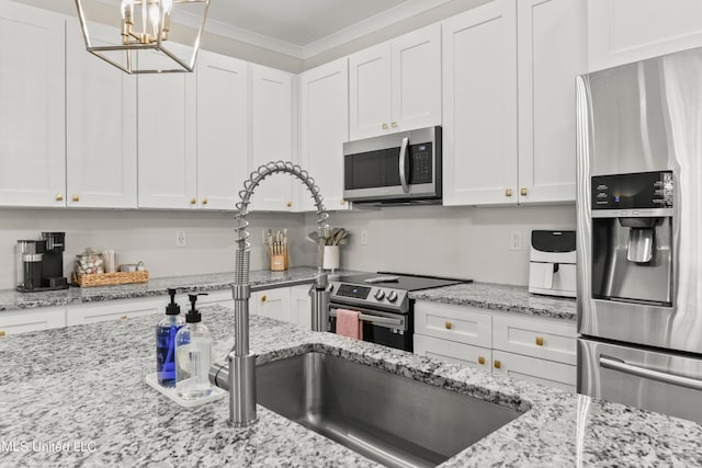 kitchen with light stone countertops, crown molding, appliances with stainless steel finishes, and white cabinetry