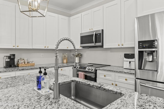 56 Oak Alley Ln, Long Beach, MS 39560 - kitchen featuring stainless steel appliances, white cabinetry, ornamental molding, a chandelier, and light stone counters