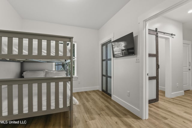 56 Oak Alley Ln, Long Beach, MS 39560 - bedroom with a barn door, light wood-style flooring, and baseboards