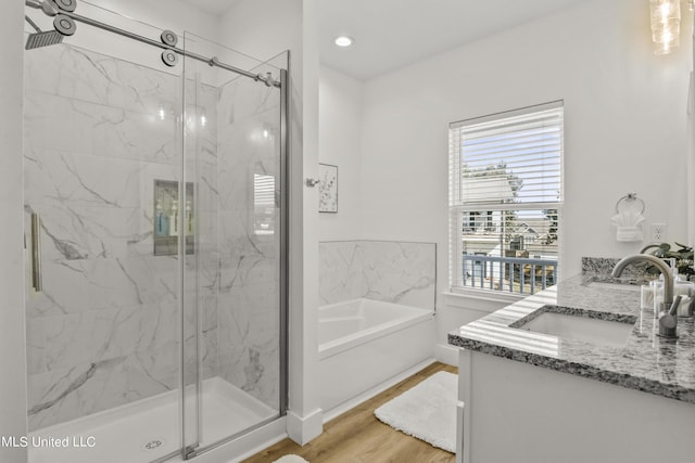 56 Oak Alley Ln, Long Beach, MS 39560 - full bath with a marble finish shower, wood finished floors, a bath, double vanity, and recessed lighting