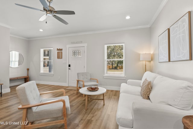 living room featuring crown molding, light wood-type flooring, and ceiling fan