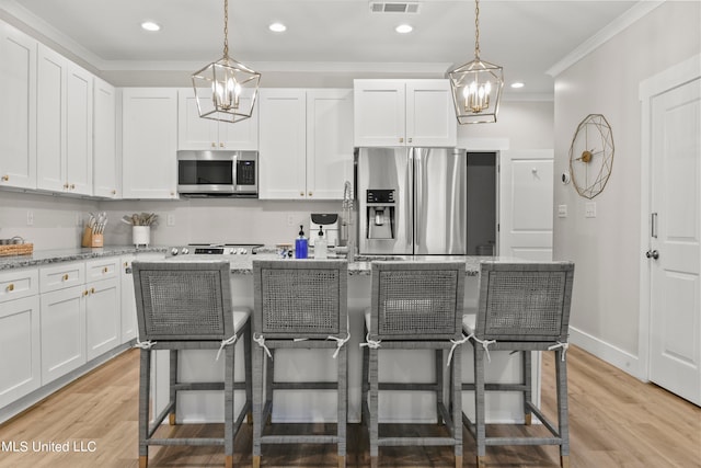 kitchen featuring light stone counters, stainless steel appliances, light wood-type flooring, and white cabinets