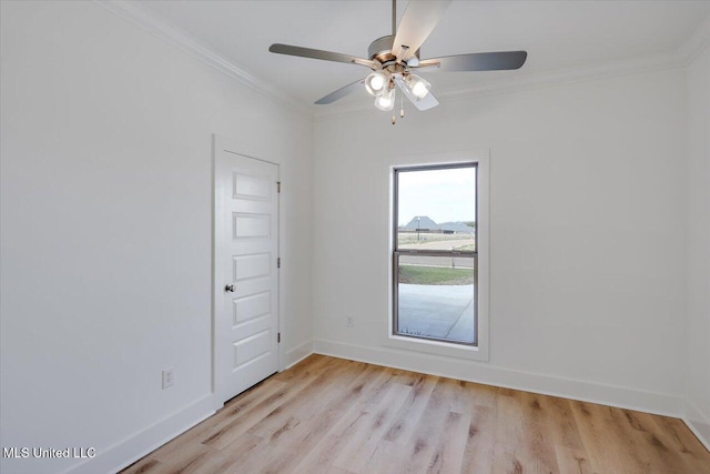 spare room featuring ornamental molding, light wood-style floors, baseboards, and a ceiling fan