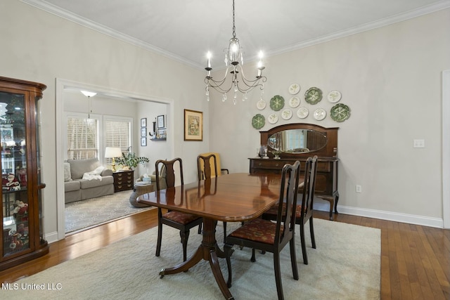 dining room featuring crown molding, hardwood / wood-style floors, and a chandelier