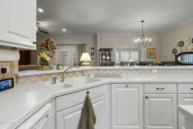 kitchen featuring sink, crown molding, white cabinetry, decorative backsplash, and ceiling fan with notable chandelier