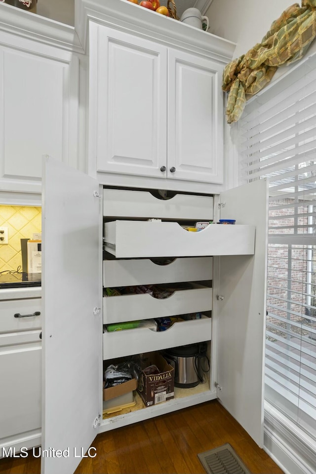 interior space featuring backsplash and wood-type flooring