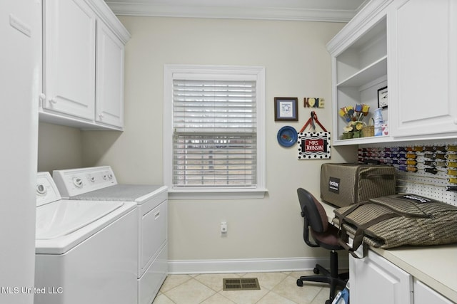 washroom with cabinets, ornamental molding, light tile patterned flooring, and washing machine and clothes dryer