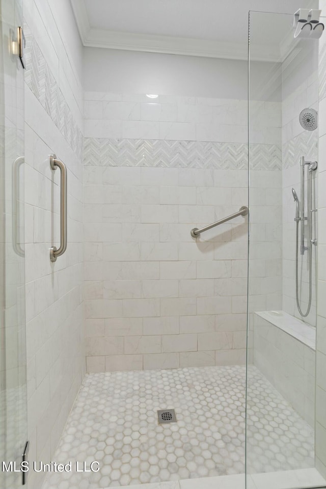 bathroom featuring a shower with door and ornamental molding