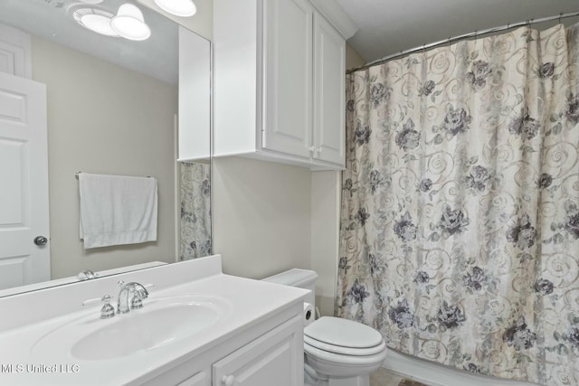 bathroom with vanity, toilet, and curtained shower