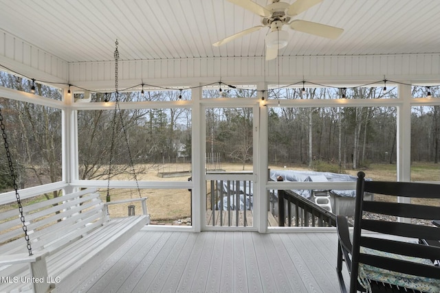 unfurnished sunroom featuring ceiling fan and a healthy amount of sunlight