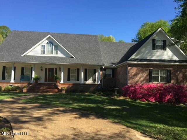 view of front of property with a porch and a front lawn