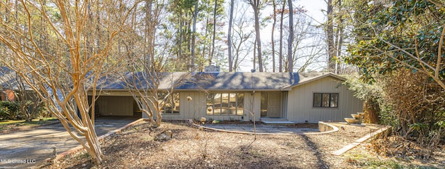 view of front of house featuring an attached carport, driveway, and a chimney