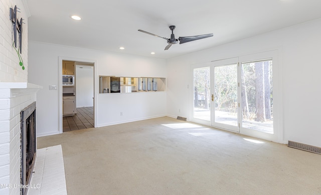 unfurnished living room with a fireplace, recessed lighting, visible vents, light carpet, and ceiling fan