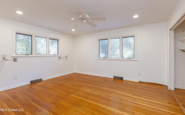 unfurnished bedroom featuring recessed lighting, visible vents, light wood-style flooring, and multiple windows