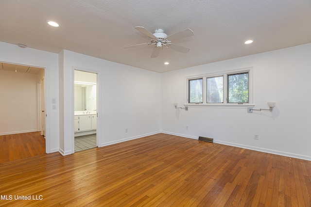 empty room featuring light wood finished floors, attic access, ceiling fan, and recessed lighting