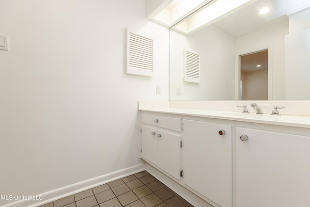 bathroom with a skylight, vanity, baseboards, and tile patterned floors