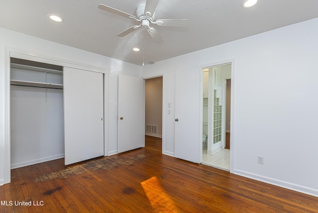 unfurnished bedroom featuring ensuite bathroom, recessed lighting, visible vents, a closet, and hardwood / wood-style floors