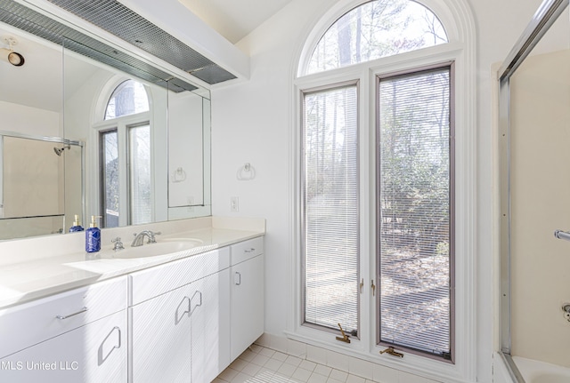 bathroom featuring tile patterned flooring, vanity, and an enclosed shower