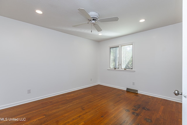 empty room featuring ceiling fan, hardwood / wood-style flooring, recessed lighting, visible vents, and baseboards