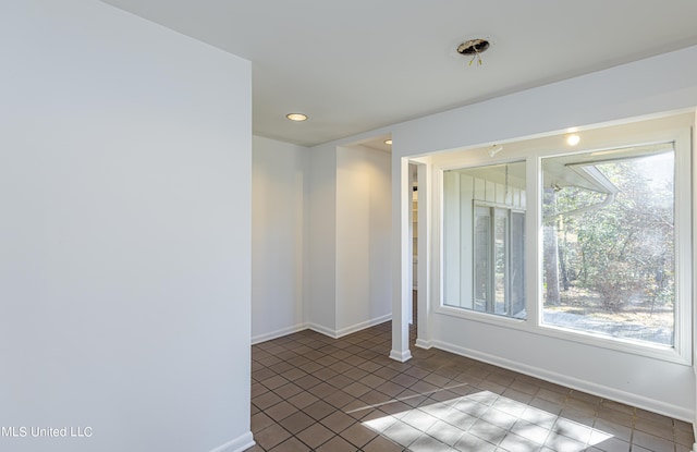 tiled empty room with recessed lighting and baseboards