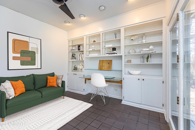 office area featuring ceiling fan, built in desk, and dark tile patterned floors