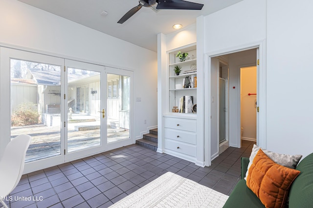 entryway featuring built in features, dark tile patterned flooring, a healthy amount of sunlight, and ceiling fan