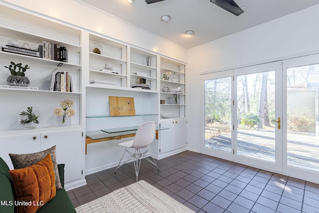 office space with dark tile patterned floors and built in study area