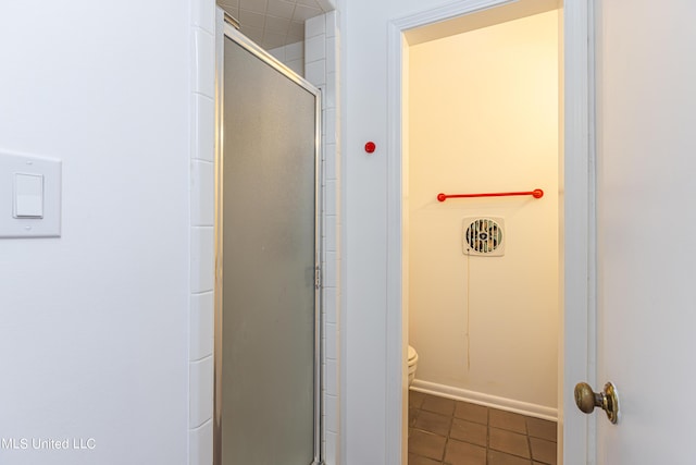 full bathroom featuring a stall shower, toilet, and tile patterned floors