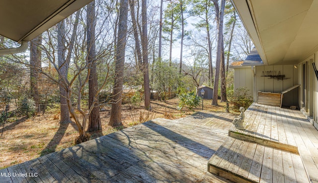 wooden deck with a storage unit and an outbuilding