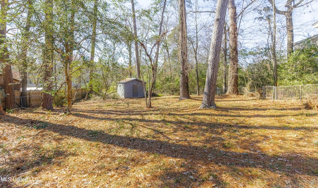 view of yard featuring a shed, fence, and an outdoor structure