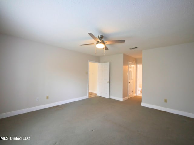 spare room featuring a ceiling fan, visible vents, carpet floors, and baseboards