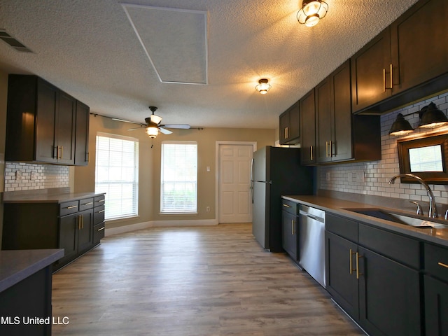 kitchen with visible vents, ceiling fan, stainless steel appliances, a sink, and light wood-style floors